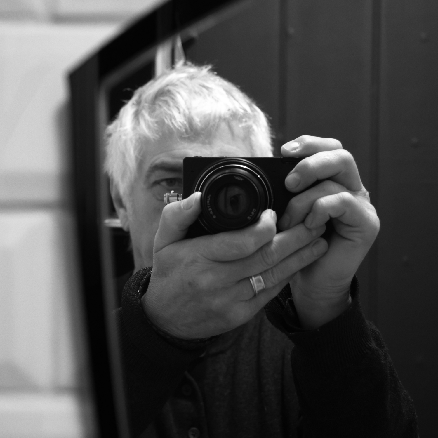 Supporting the camera with the left hand.