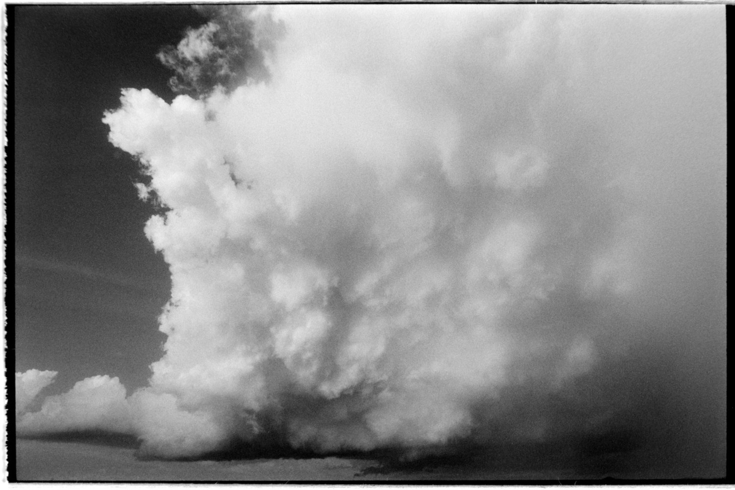 Big white storm clouds with rain in the distance.