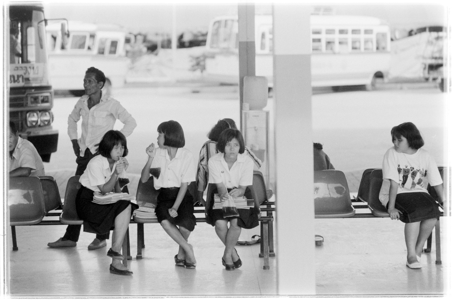 Schoolgirls waiting for their bus to arrive.